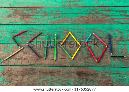 write school with colorful pens on the green wooden background for education and back to school concept. 