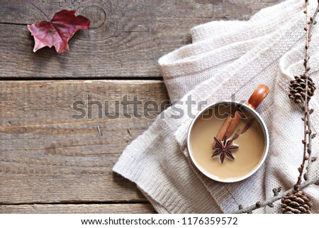 Coffee or tea with milk and spices. Rustic autumn background. Overhead view, copy space