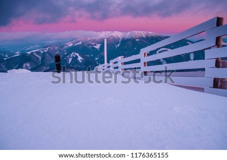 Beautiful white winter mountains, colorful purple sunset in background. Landscape in christmas time, edit space