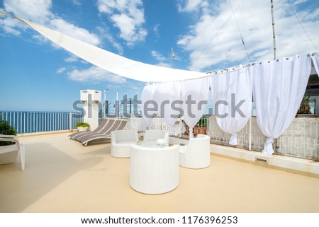 Rooftop terrace prepared for a baby shower. White and bright design to represent innocence and newlife. Beautiful patio with herbs and plants. Cactus in the background  
