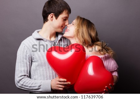 Young happy couple with red balloon