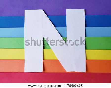 letter N in white and background with rainbow colors