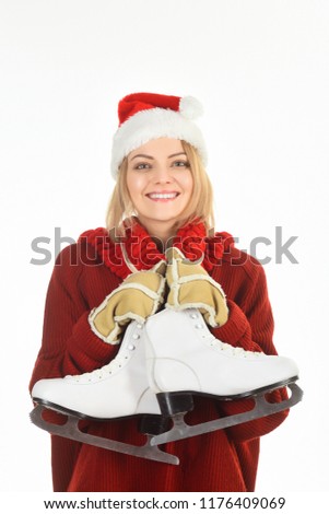 Ice skating. Girl figure skater. Figure skating school. Weekends activities in cold weather. Ice skater. Woman in warm sweater Santa hat and mittens holds figure skates. Smiling woman with skate shoes