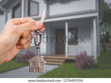 House key in hand on blurred background