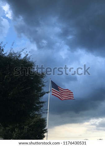 American flag waving storm cloud in sky
