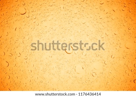 Rain droplets on yellow glass background, Water drops on yellow glass.