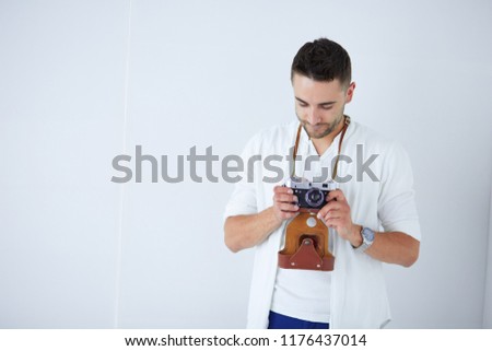 Young man with camera. Isolated over white background.