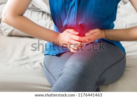 Woman having painful stomach ache at home,Female suffering from abdominal pain,Period cramps,Hands squeezing belly,Stomach pain,Menstrual cramps,Pelvic bone,Dysmenorrhea Royalty-Free Stock Photo #1176441463