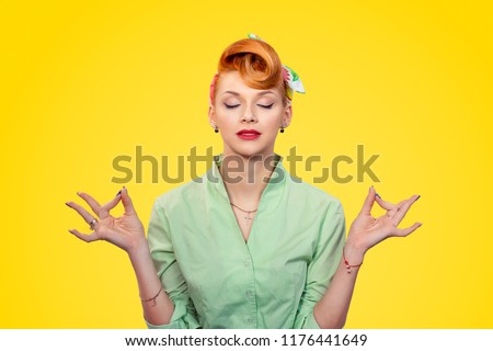 Meditation. Closeup red head young Business woman pretty pinup girl green button shirt meditating with eyes closed isolated yellow background retro vintage 50's style. Human emotions body language