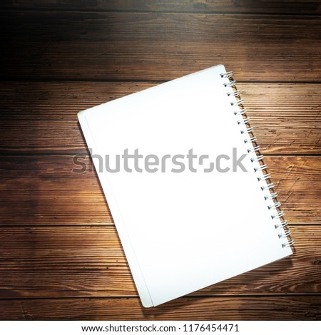 Blank notebook on wooden table. Opened notepad on top of a desk. Blank Catalog on the wooden background for your design.