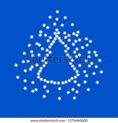 Sugar decoration in form of snowflakes forming silhouette of Christmas tree. Scattering of snowflakes on blue background with space for text. Minimal Christmas and New Year's concept