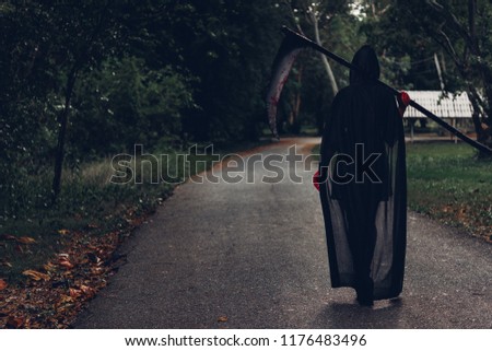 Back woman horror ghost holding reaper in forest, halloween concept