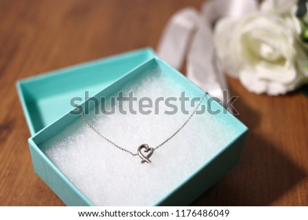 Present heart necklace and white rose flower