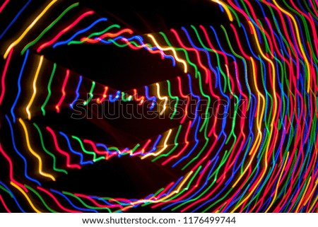 Light trails from moving camera capturing Christmas lights at night.