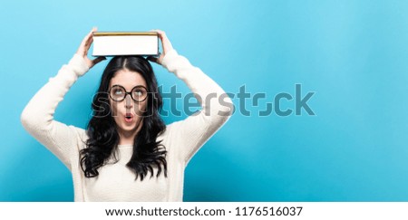 Young woman with a book on a solid background
