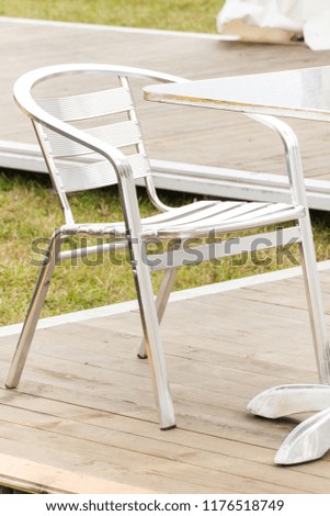 Metal silver chair and table on fresh air in outdoor restaurant or cafe