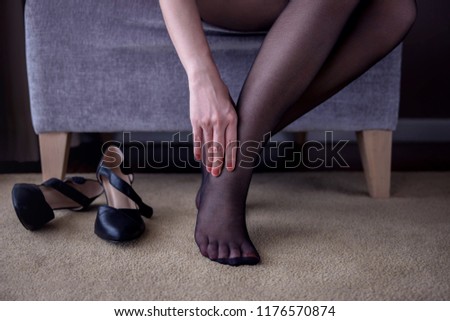 Health Care Concept. Business Woman Suffering from Pain in Ankle or Foot, Effect from Walking all day or wearing Uncomfortable High Heel Shoes, sitting on Chair in House