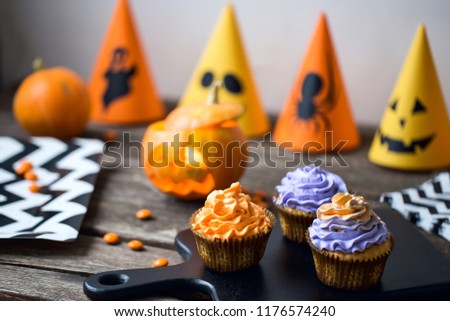 halloween party cupcakes decoration on wooden table orange and purple colors