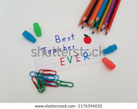 Best teacher ever note card, Note to teacher with colored pencils, erasers and paper clips laying on a white background, Back to school, School supplies, 