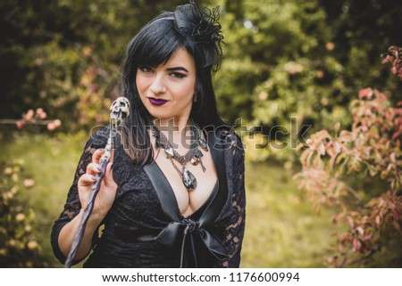Gothic lady in a glamorous vintage look for Halloween, witch with Magic wand. Beautiful citizen in vintage clothing pretty accessories of handmade work. Ideas for the Halloween holiday