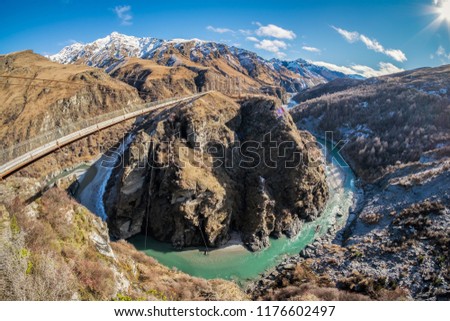 Located in New Zealand's South Island, the Skippers Canyon Road is known for its scenic roads, and scary narrow road. There are steep sheer cliff face. Below is the famous shotover river stream. Royalty-Free Stock Photo #1176602497