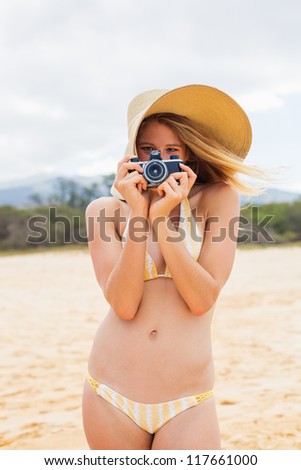 Beautiful Young Woman at the Beach with Vintage Camera