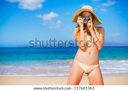 Beautiful Young Woman at the Beach with Vintage Camera