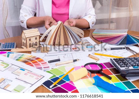 Designer's hands showing colourful sampler at workplace