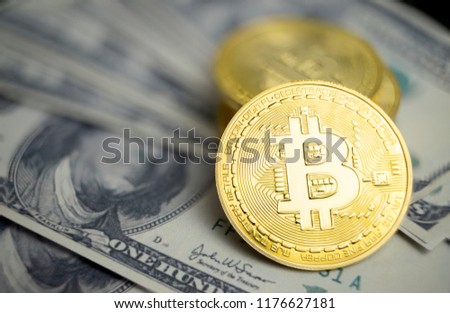 Golden bitcoin cryptocurrency on us dollars close up