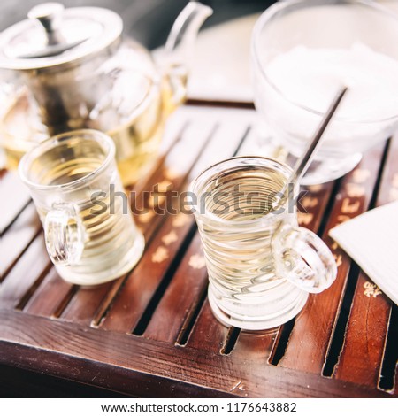Freshly brewed herbal tea in glasses in oriental wooden tray. Hookah.