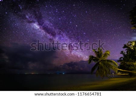 Amazing landscape view of a Milky Way at night sky, with grain. Tropical island night sky and palm trees in Maldives islands