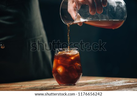 Pouring cold brew coffee Royalty-Free Stock Photo #1176656242