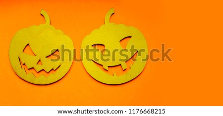 two wooden pumpkins on orange paper background . empty copy space for inscription 