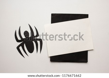 Minimalistic card mockup with paper spider and bats, flat lay, top view  Workspace. Halloween invitation card with copy space