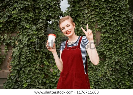 green bushy front garden woman holding a glass of glass with a drink in her hand                              