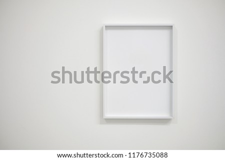 Empty white frame on white wall for interior decoration. Minimal concept.