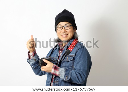 The Asian man with denim shirt and beanie standing on the white background.