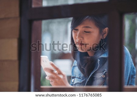beautiful woman typing text message on smart phone in a cafe