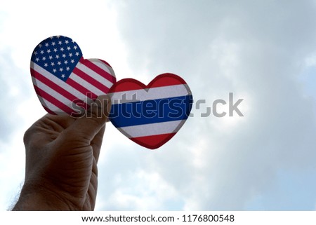 Hand holds a heart Shape USA and Thailand flag, love between two countries