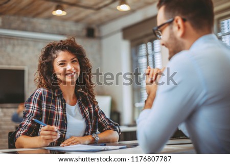 Young woman signing contract with manager Royalty-Free Stock Photo #1176807787