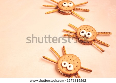 Group of double Halloween spider cookies on pink wooden background. Top view with copyspace. Halloween items and decoration concept