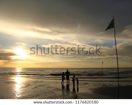 Family enjoy sunrise at the sea in Hua Hin beach, Thailand.