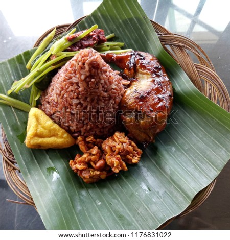 Nasi merah alas daun ayam panggang kangkung tahu tempe. Traditional food of indonesia. Image print for article, background. 