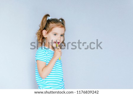Funny little girl brushing her teeth.  Health care, oral hygiene, people and beauty concept. Layout, free space. Selective focus.