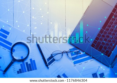 Magnifying glass and documents with analytics data lying on table,selective focus Royalty-Free Stock Photo #1176846304