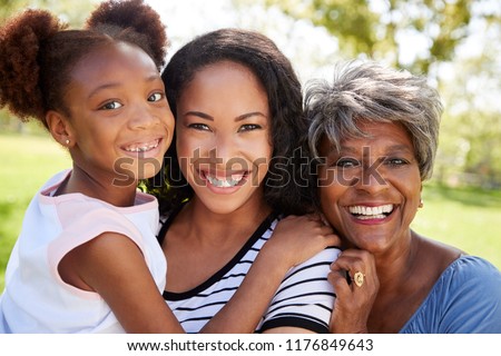 Portrait Of Grandmother With Adult Daughter And Granddaughter Relaxing In Park Royalty-Free Stock Photo #1176849643