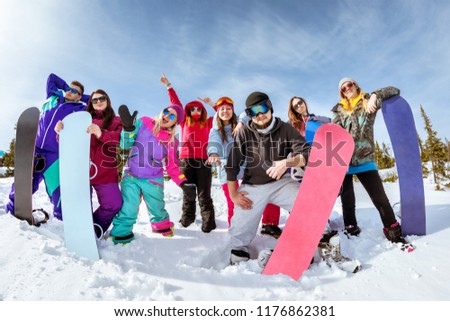 Group of happy friends snowboarders having fun at ski resort. Winter vacations concept