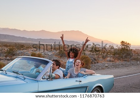 Group Of Friends On Road Trip Driving Classic Convertible Car Royalty-Free Stock Photo #1176870763