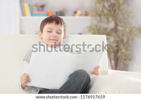 boy reads a book on the couch in the nursery.photo with copy space