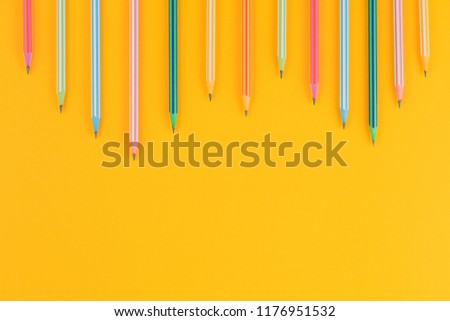 multicolored pencils on a yellow isolated background, office supplies, top view. a lot of free space. flat lay concept.